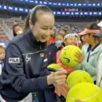 Chinese tennis player Peng Shuai signs large-sized tennis balls at the opening ceremony of Fila Kids Junior Tennis Challenger Final in Beijing, China November 21, 2021