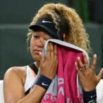 Naomi Osaka wipes her face as she talks to referee Claire Wood after a spectator disrupted play, yelling "Naomi you suck," before the start of her 2nd round match against Veronika Kudermetova at the BNP Paribas open at the Indian Wells Tennis Garden.