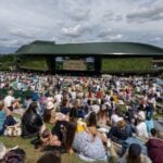 Spectators watch the men's final on a large screen as they sit on Henman Hill at the All England Lawn Tennis and Croquet Club, London, Britain