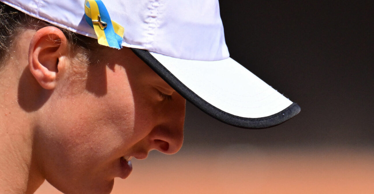 A blue and yellow ribbon in support of Ukraine amid Russia's invasion is pinned to the cap of Poland's Iga Swiatek at the 2022 Italian Open in Rome