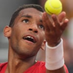 Auger-Aliassime hiting a serve