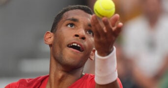 Auger-Aliassime hiting a serve