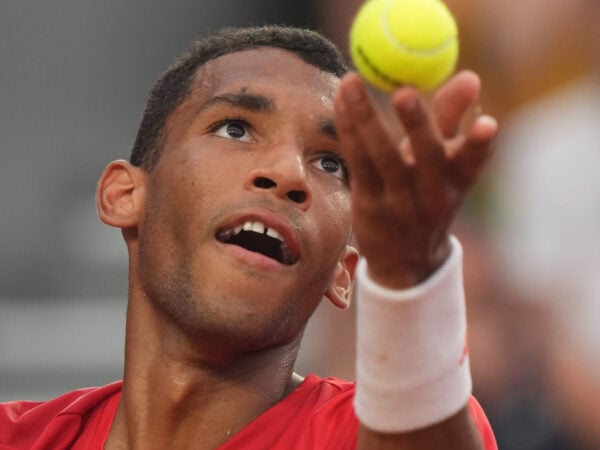 Auger-Aliassime hiting a serve