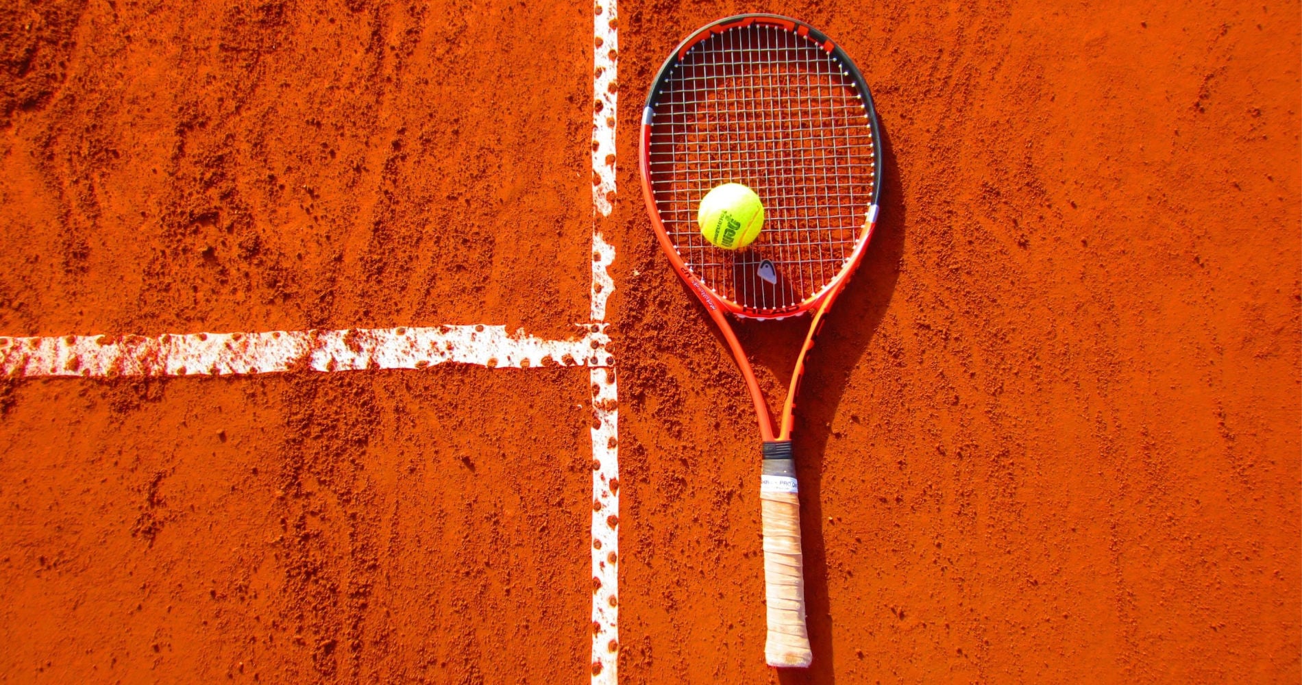Tennis racket on a red clay court