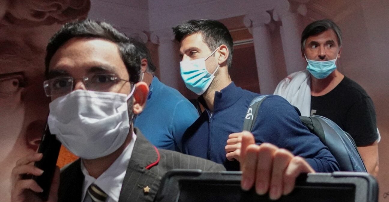 Novak Djokovic walks with his team after landing at Dubai Airport after the Australian Federal Court upheld a government decision to cancel his visa to play in the Australian Open on January 17, 2022.