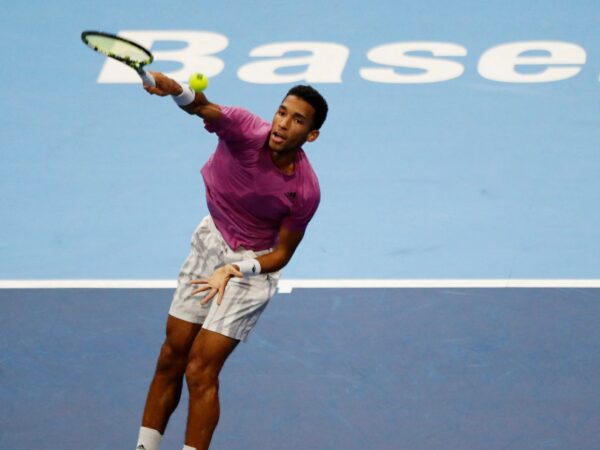 Felix Auger-Aliassme hits an overhead against Alexander Bublik in Basel in 2022