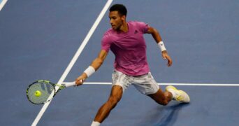 Felix Auger Aliassime hits a forehand close to the net in Basel in 2022