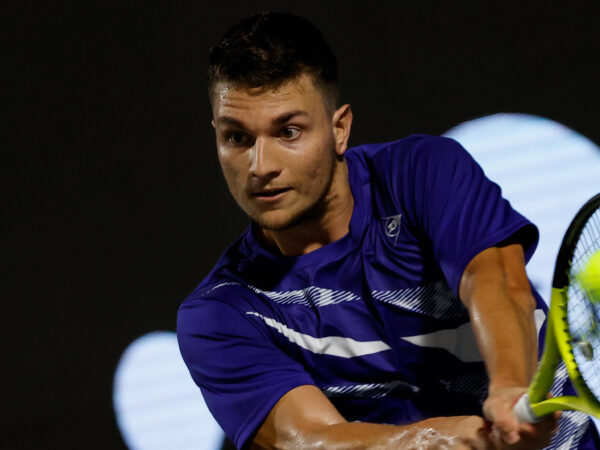 Miomir Kecmanovic is hitting a backhand during a match in Napoli in 2022